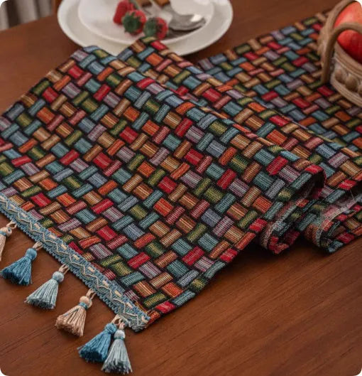 Country European retro style table flag with long handwoven tassels draped over a wooden sideboard.