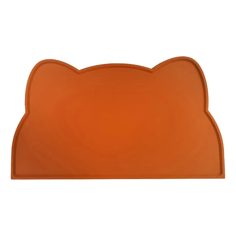 Blue silicone cat head-shaped pet feeding mat on a wooden floor.