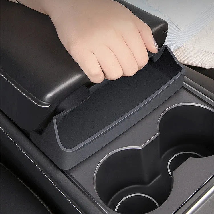 Black silicone glasses case mounted on a Tesla Model 3 or Y central armrest.