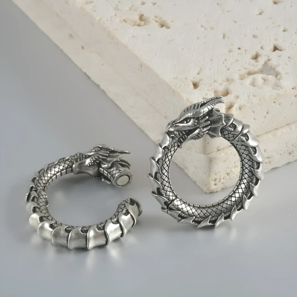 A pair of large antique silver alloy earrings featuring a hollow out geometric dragon design.