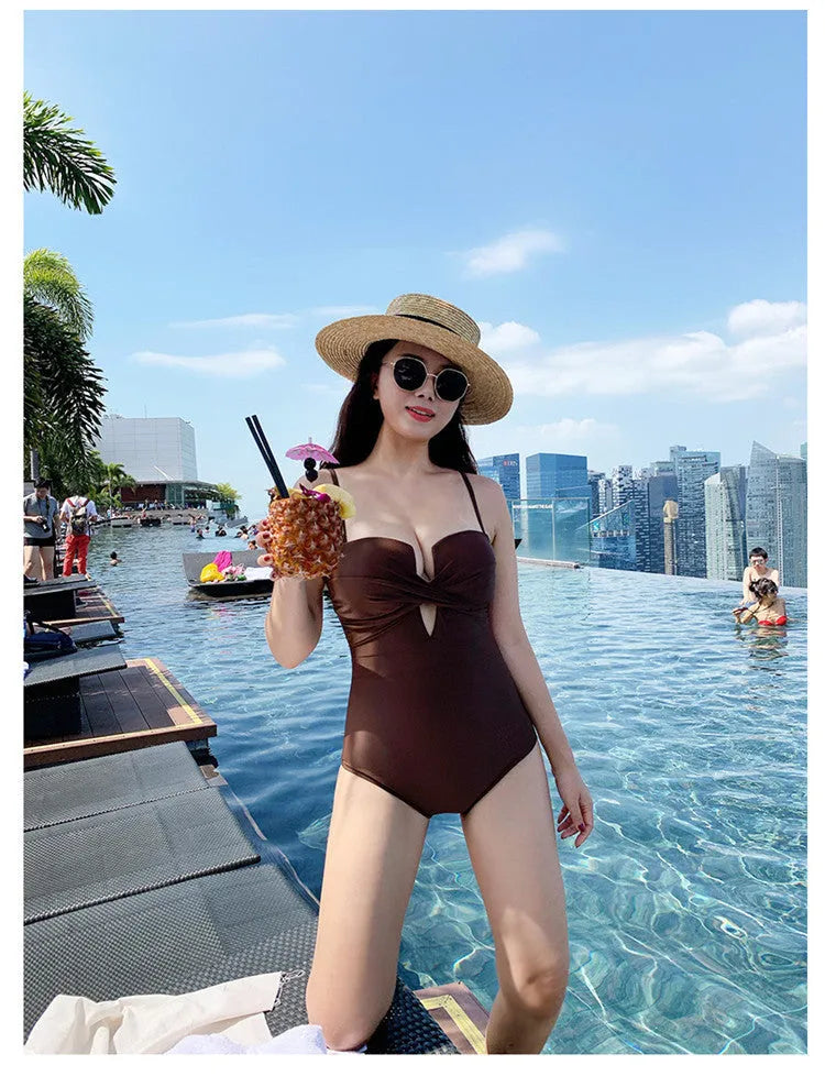 White one-piece swimsuit with spaghetti straps and push-up design on a mannequin.
