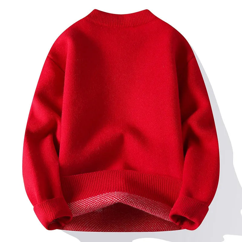Man wearing a grey loose fit knitted pullover with long sleeves and a ribbed hemline.