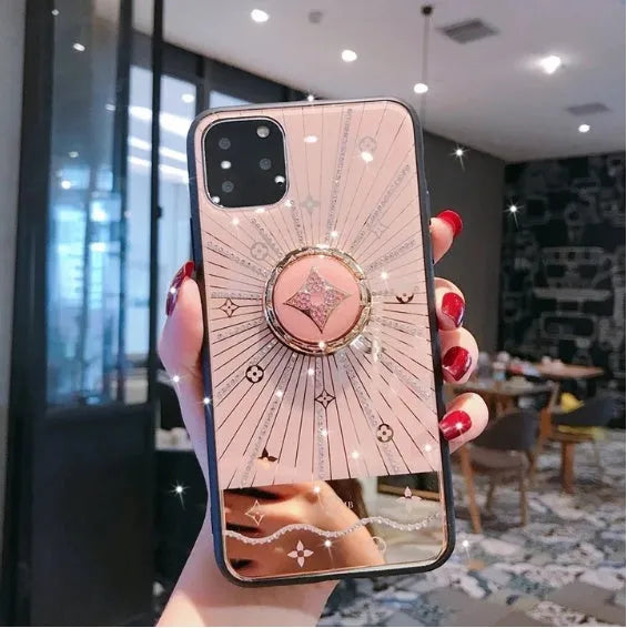 Luxury diamond and gold ring holder stand holding an iPhone for hands-free viewing.