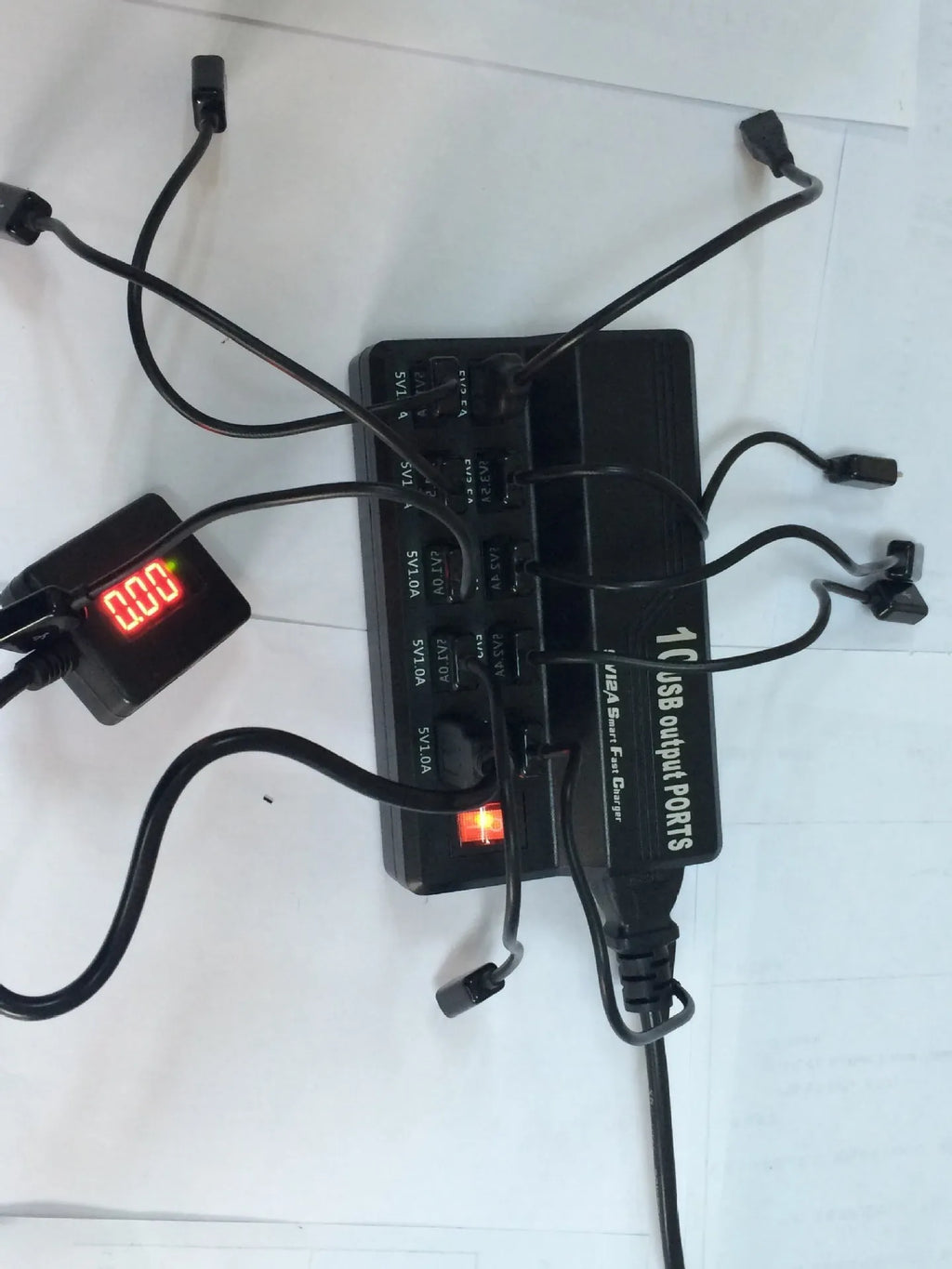 Black 10-port USB charging power strip with smart charging and aluminium heat dissipation, shown with multiple cables connected