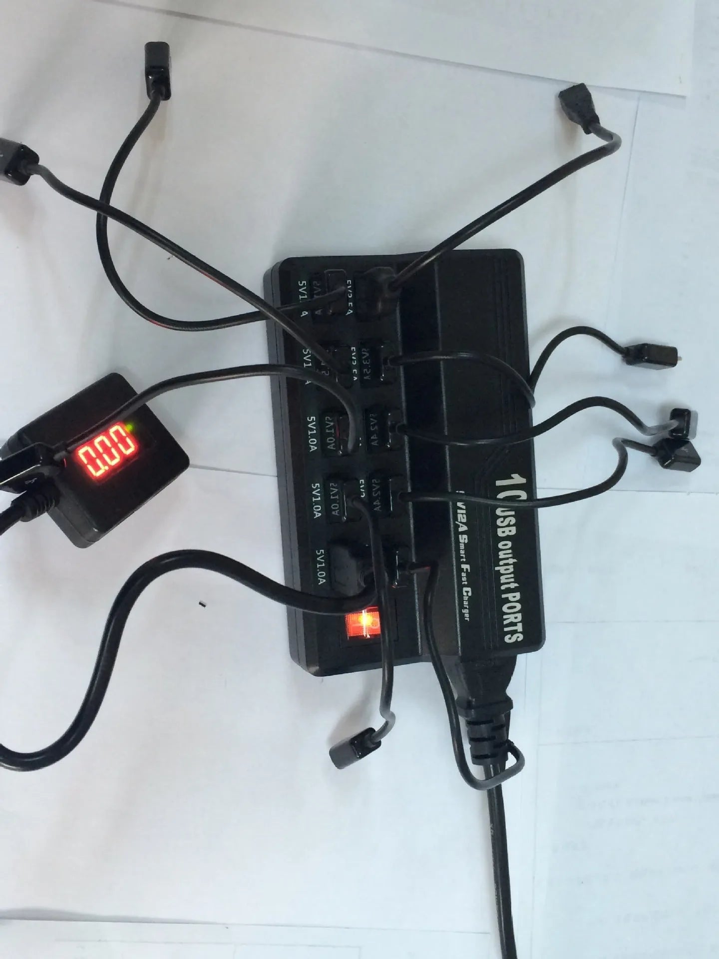 Black 10-port USB charging power strip with smart charging and aluminium heat dissipation, shown with multiple cables connected