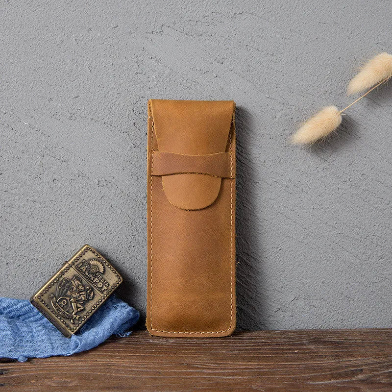 Brown leather pencil case with zip opening on a plain background