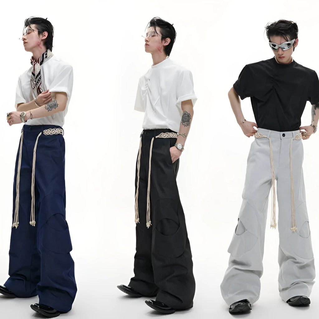 Man wearing dark blue straight-leg cotton jeans with loose fit, zipper decorations, and a tassel detail.