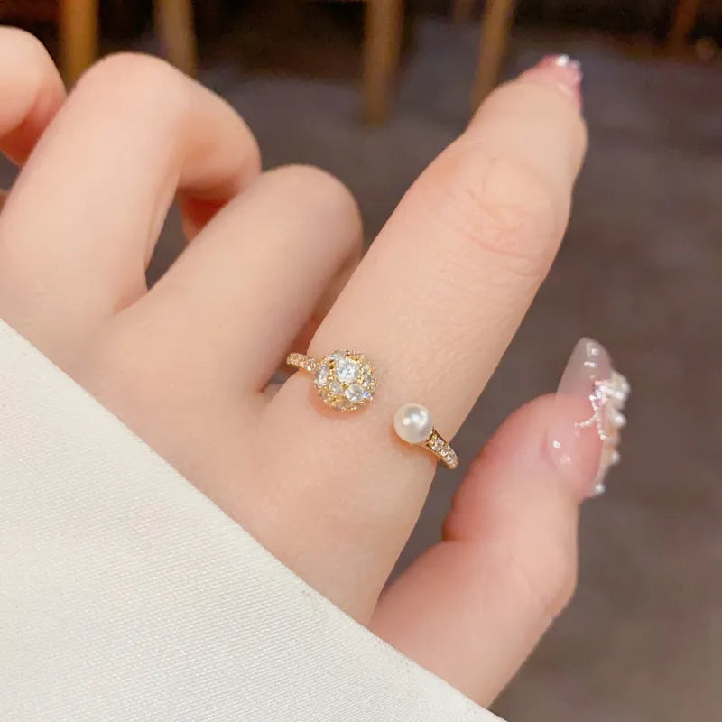 Gold and silver open-end women's ring with round zircon stones and pearl design on geometric band