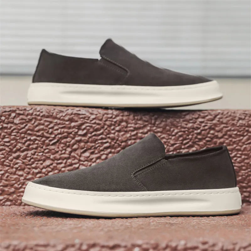 Men's grey slip-on casual shoes with round toe design and visible stitching details