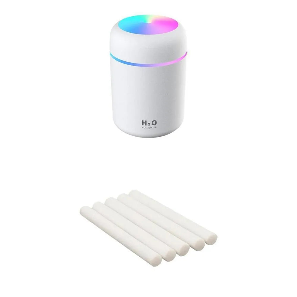Pink USB desktop humidifier with LED lights and water tank on a wooden desk.