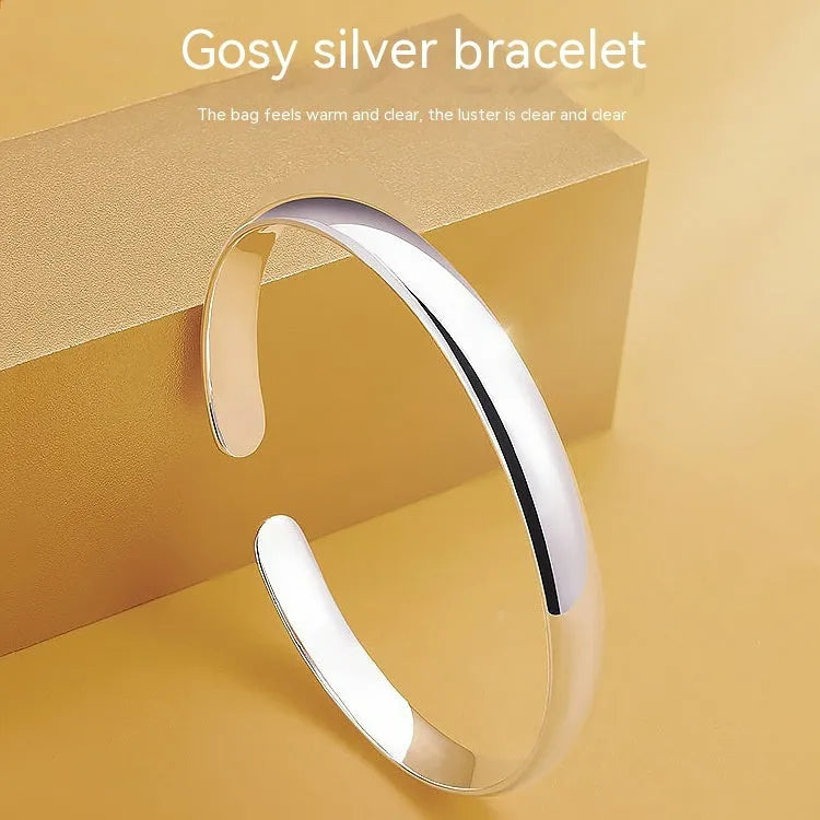 Glossy silver-plated copper bracelet with Ruyi and lucky cat charms on white background