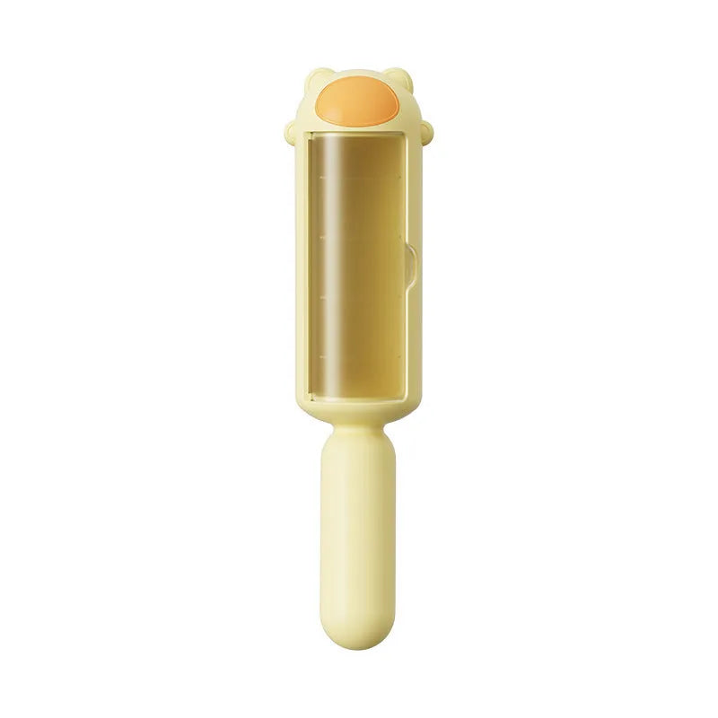 Blue reusable pet hair remover roller with self-cleaning base on a grey sofa.