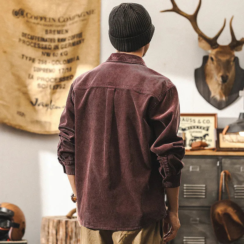 Man wearing a loose-fit black corduroy shirt jacket with long sleeves.