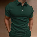Man wearing a loose fit grey cotton blend T-shirt with a button-down front and short sleeves.