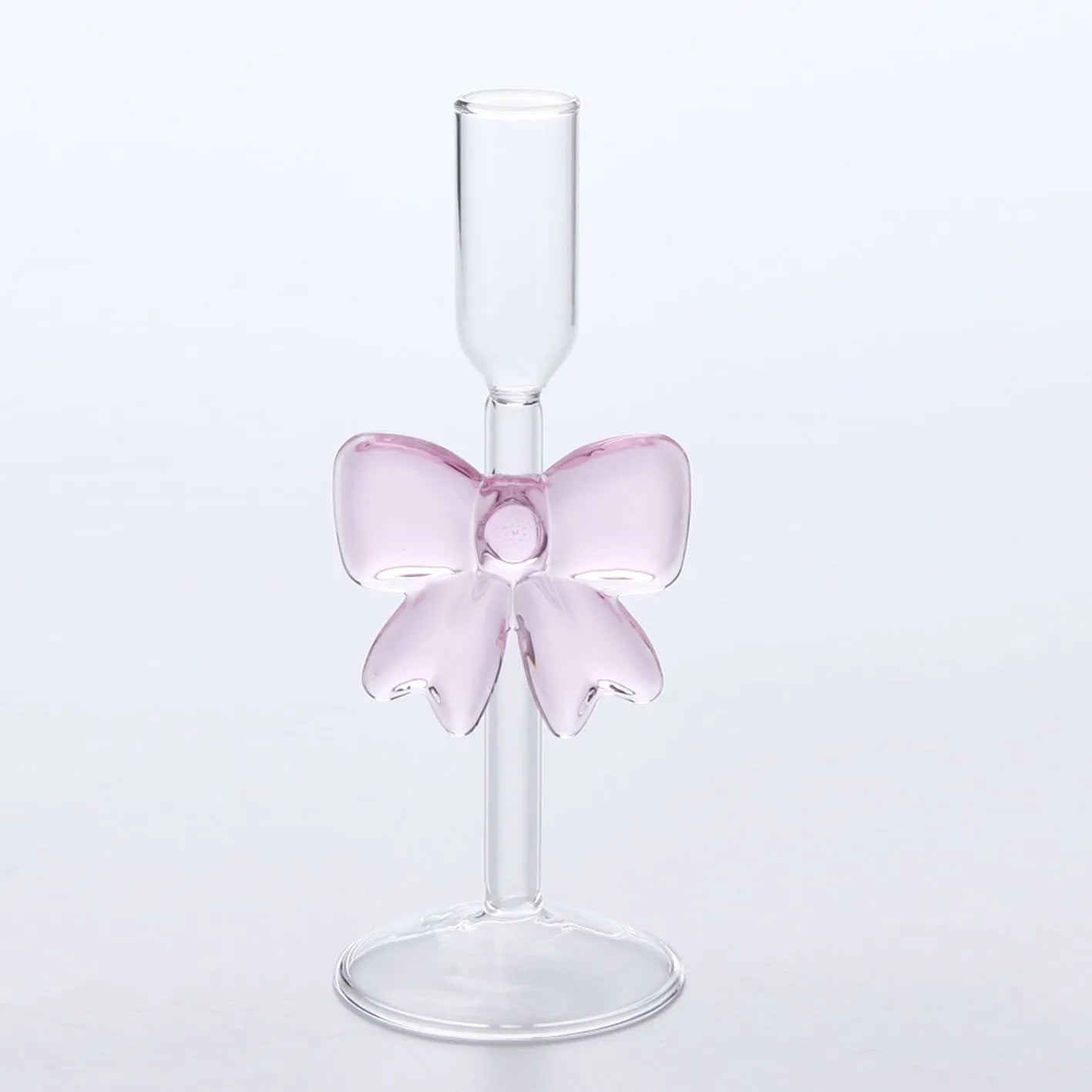 Set of three clear borosilicate glass candlesticks with large bow decorations on a table