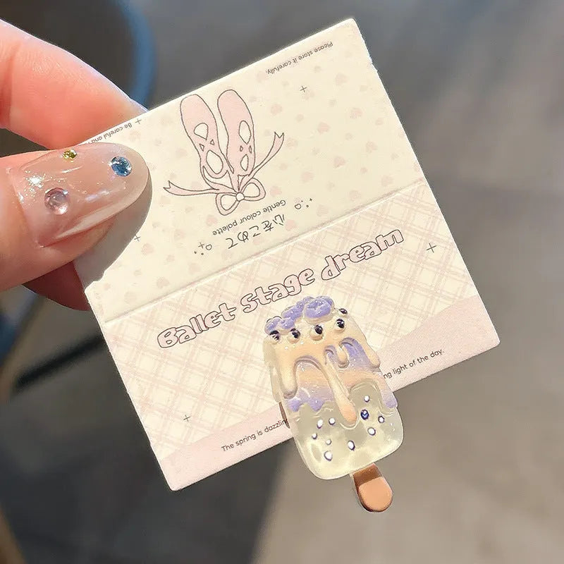 Close-up of a handmade resin hair barrette with a cute cartoon ice cream design in a choice of colours.