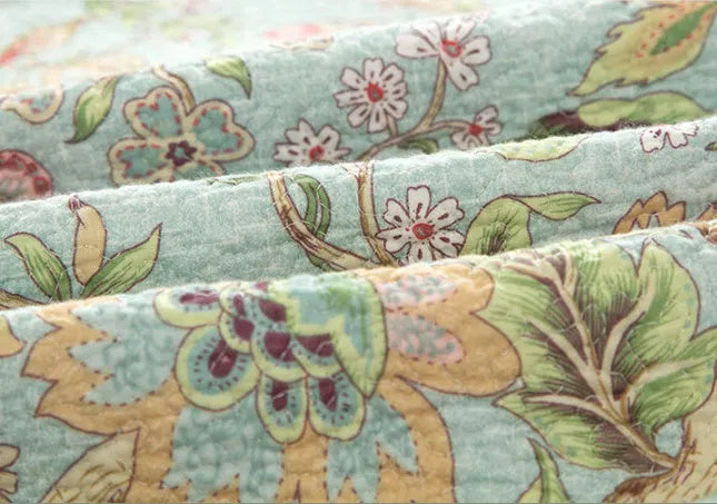 Blue American floral pattern cotton quilted bedspread set with three pieces on a bed