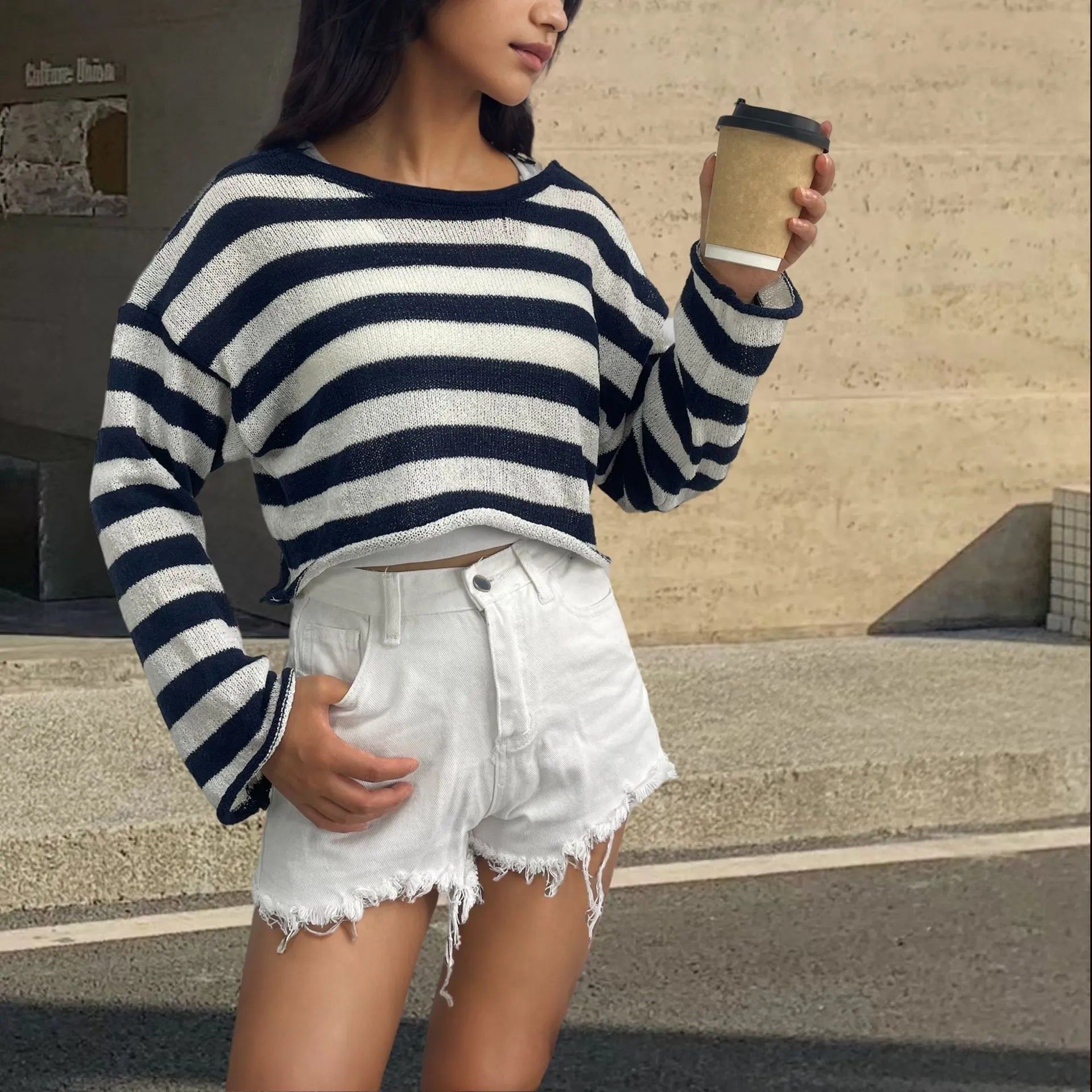 Woman wearing a striped long-sleeved cropped sweater in mercerised cotton, showcasing front and back wearable design.