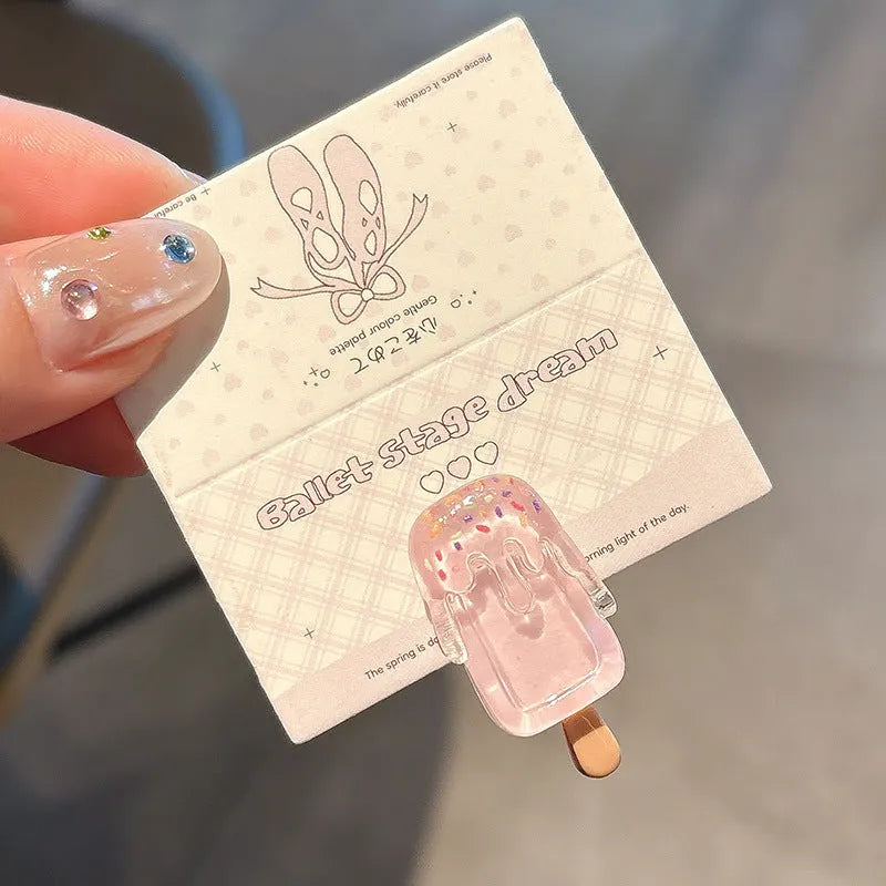 Close-up of a handmade resin hair barrette with a cute cartoon ice cream design in a choice of colours.