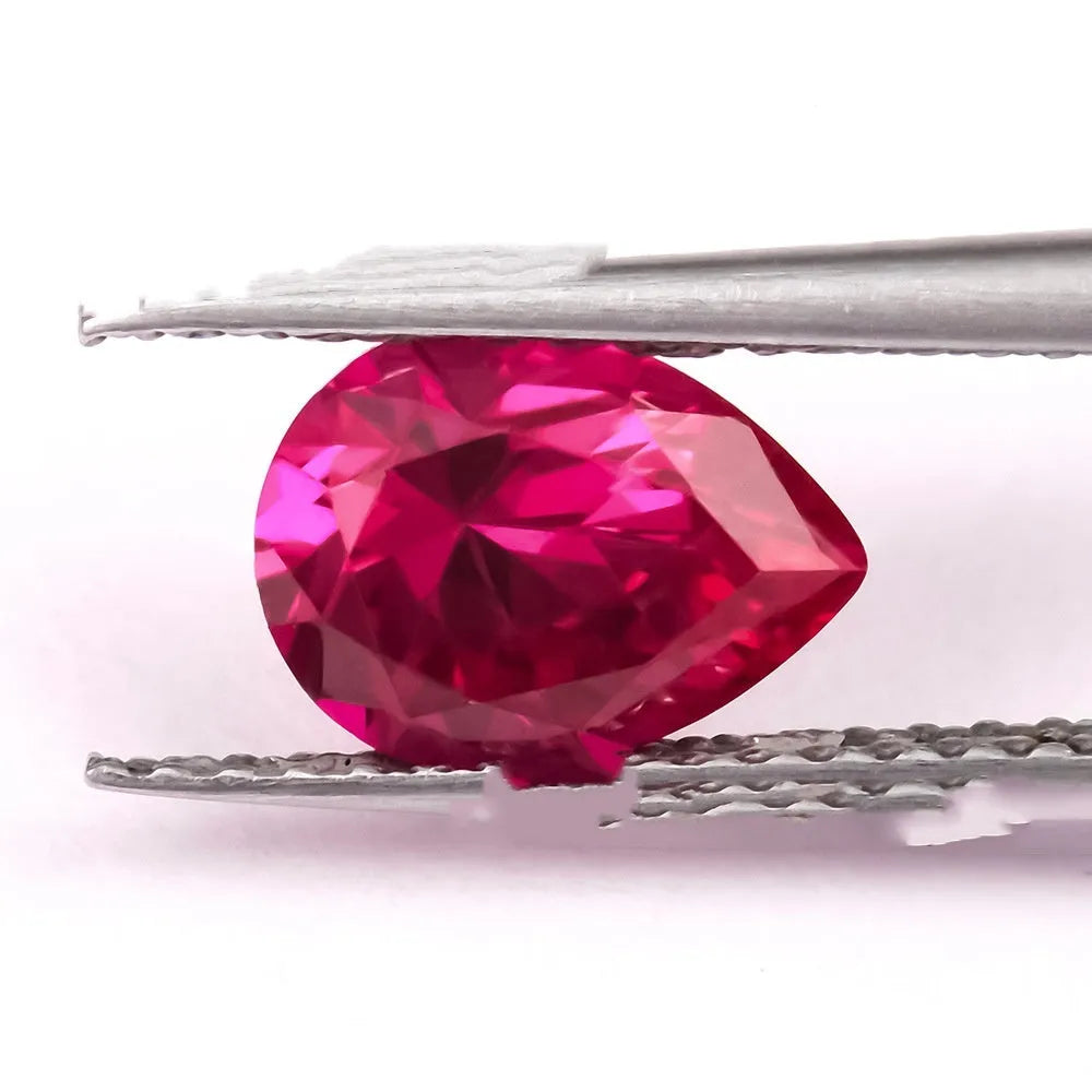 Loose cultivated pigeon blood red ruby gemstone in a princess cut on a grey background.
