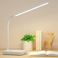 White USB charging folding LED desk lamp with touch switch and lithium battery on a desk