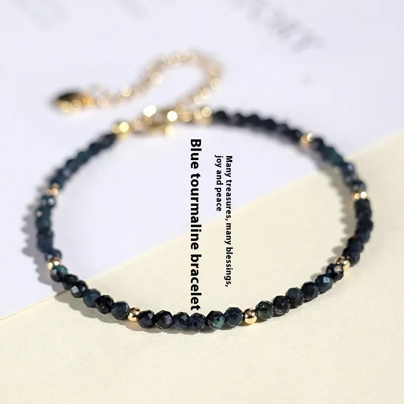 Close-up of a women's blue tourmaline beaded bracelet with 3mm gemstone beads and spacer details.