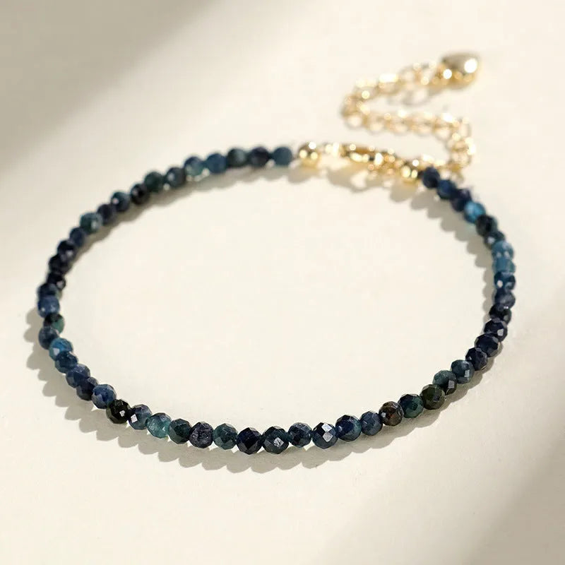 Close-up of a women's blue tourmaline beaded bracelet with 3mm gemstone beads and spacer details.