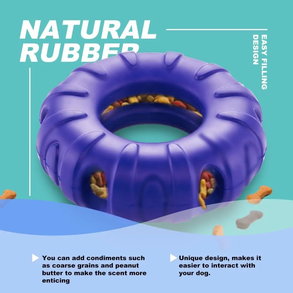 Blue tyre-shaped dog chew toy with oval openings for treat dispensing on a wooden floor.