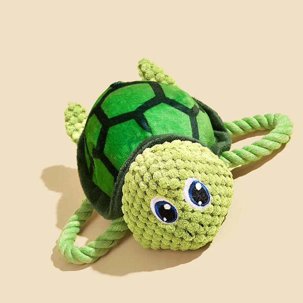 Grey turtle-shaped plush dog chew toy with textured knots on its shell.