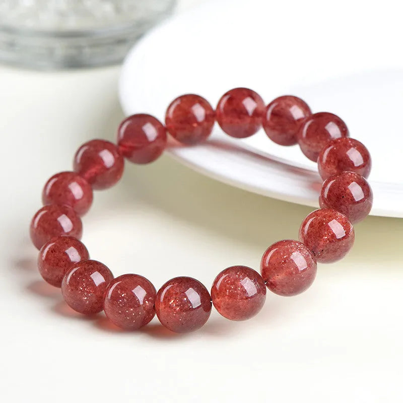 Natural red strawberry quartz crystal bracelet with geometric cut beads, shown in unisex styling.