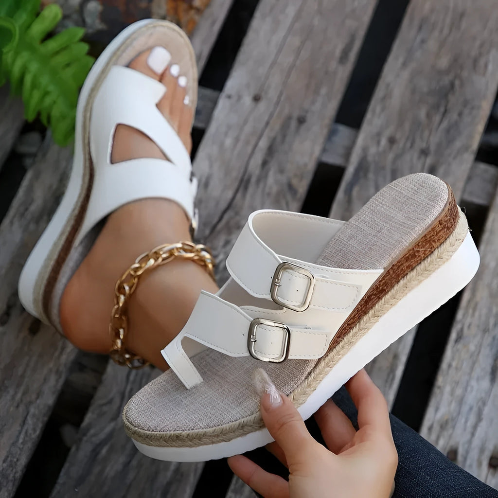 White patent leather wedge sandals with peep toe and woven design on model