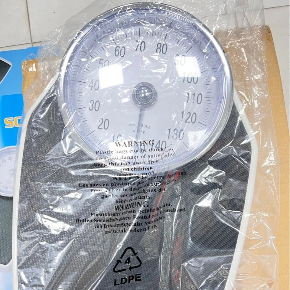 Black mechanical bathroom scale with large analogue dial display on white background