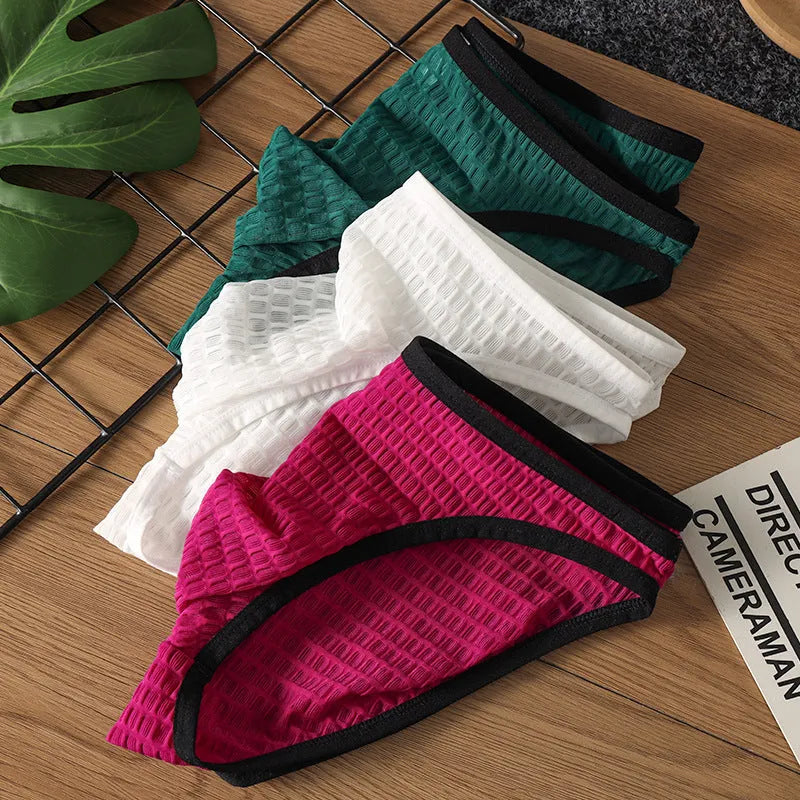 Men's low waist transparent lace underwear shorts in a solid colour on a neutral background.