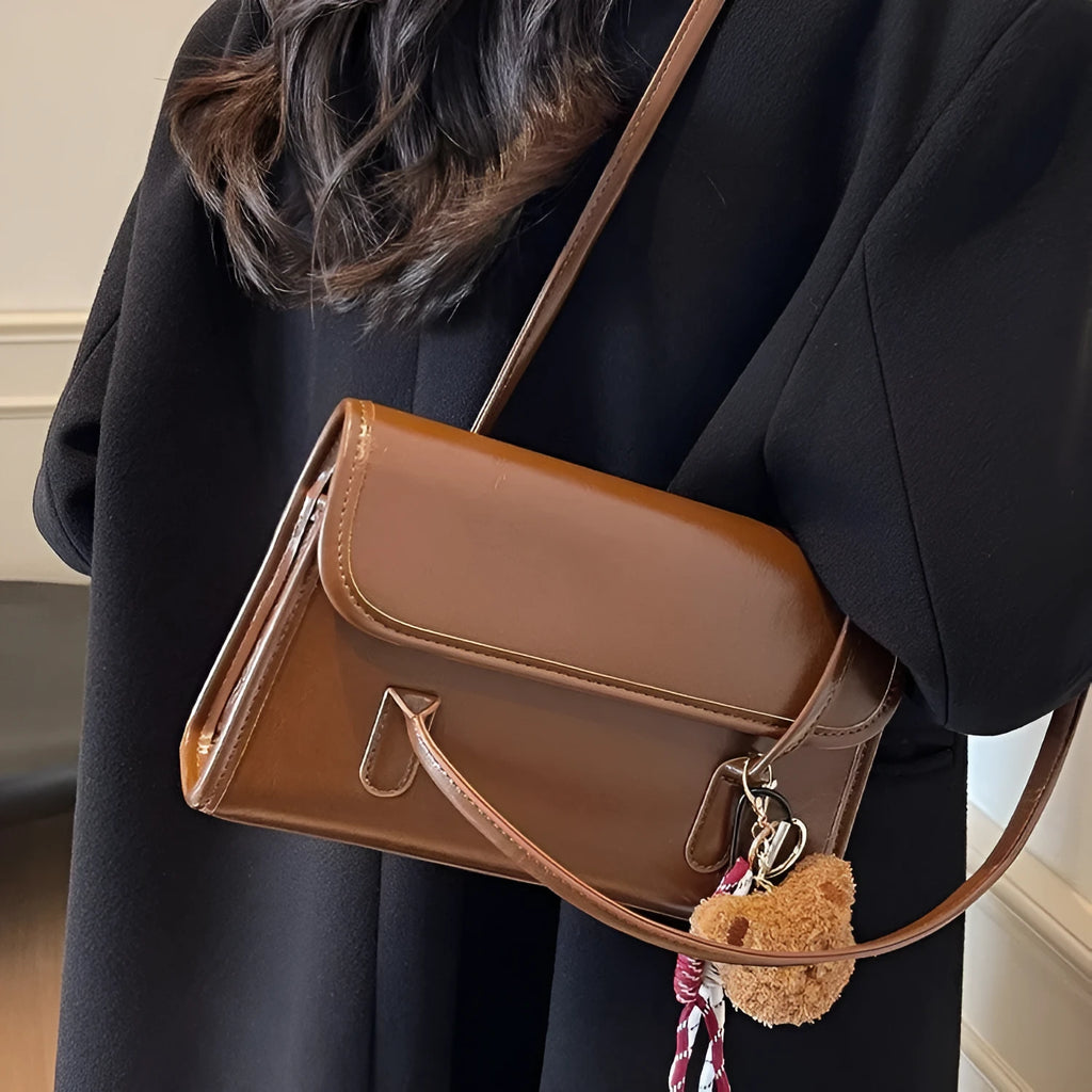 Brown women's Maillard-style PU leather shoulder bag with a double strap and a removable pendant accessory.