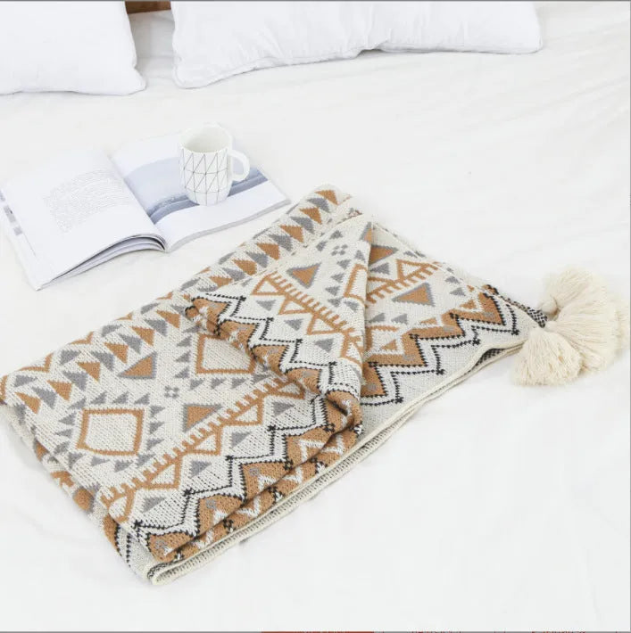 Acrylic sofa blanket with tassel fringe in geometric pattern, showing 130 cm width measurement