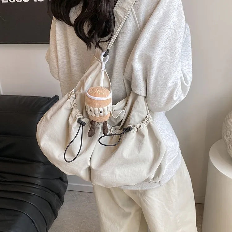 Green pleated crossbody student bag showing foldable polyester construction and internal mobile phone pocket