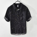 A man's loose-fit short-sleeved polo shirt in black, showing the lapel collar and casual cardigan style.