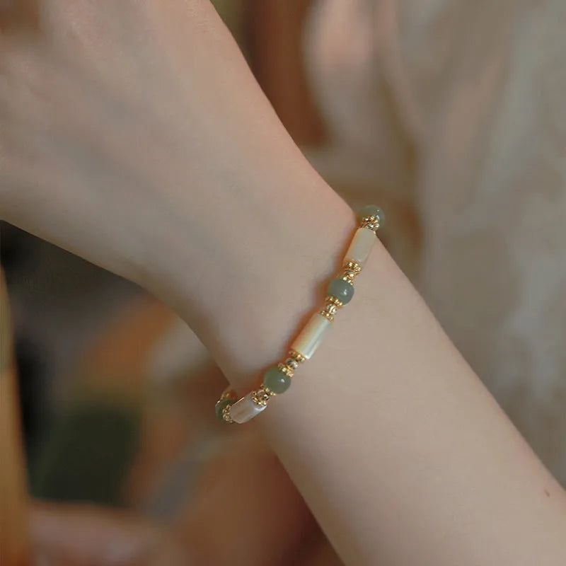 Handmade women's Hetian jade bracelet with round beads in geometric design on wrist