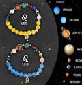 Two natural stone beaded bracelets with zodiac sign charms on a wooden surface