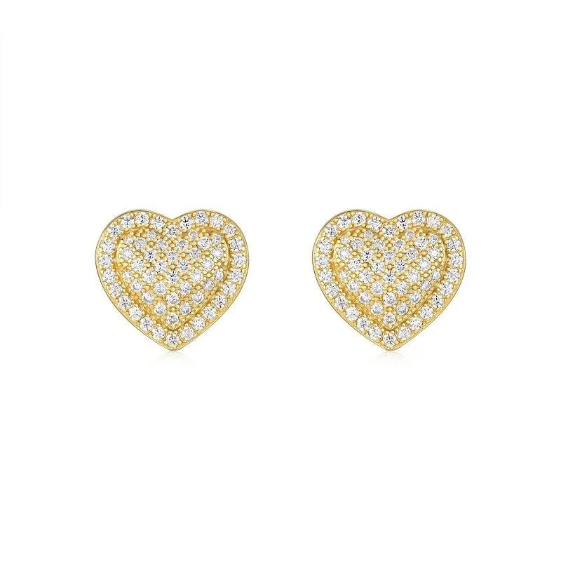 A pair of gold-colour heart-shaped stud earrings with a moissanite stone, on a plain background.