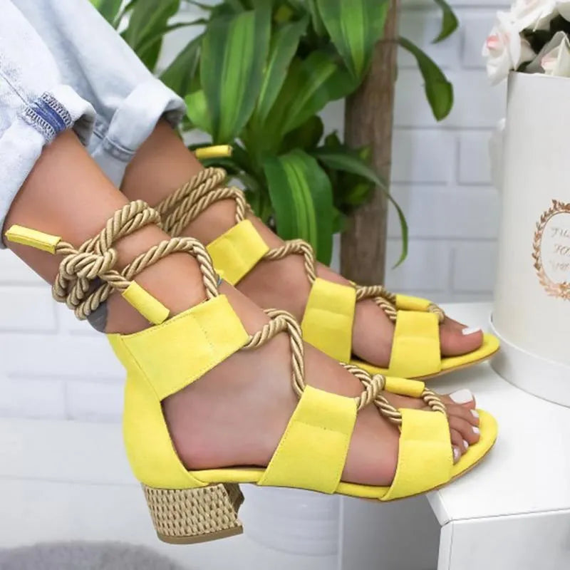 Women's beige suede sandals with thick heel, front strap, and ankle strap on a white background.