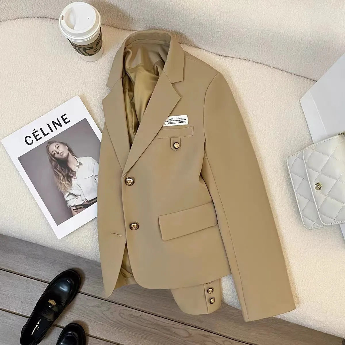 Black women's loose-fit short suit coat with long sleeves and pockets.