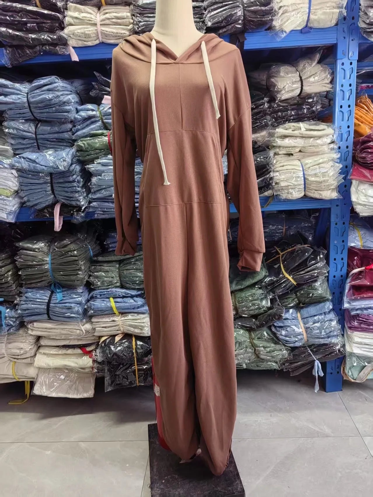 Women's solid colour hooded jumpsuit in black with long sleeves and front pockets on a plain background