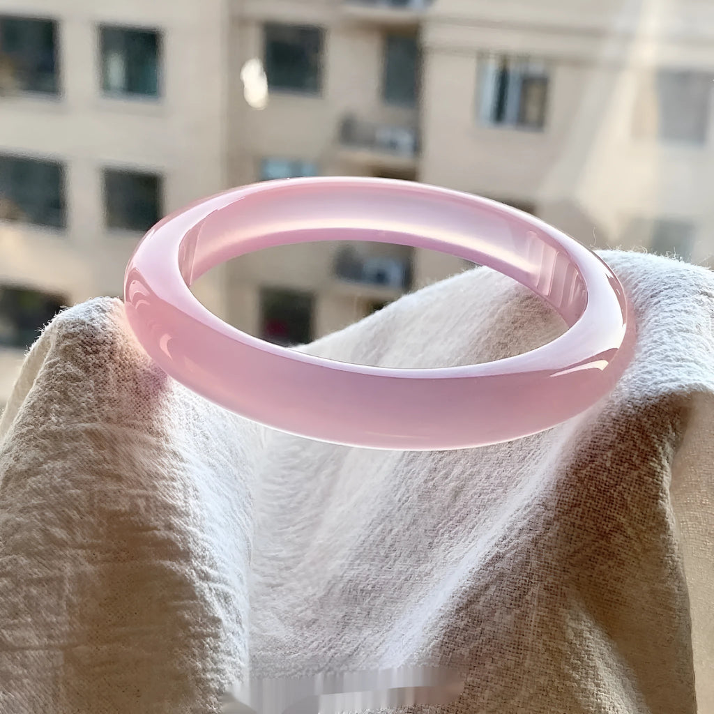 Natural agate wide tire bracelet in pink stone with size options from 52 to 62 mm circumference.
