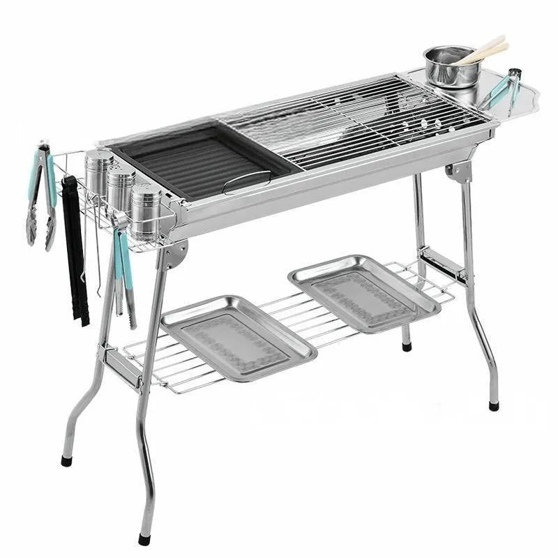 Stainless steel portable folding barbecue oven with grills, shown outdoors.