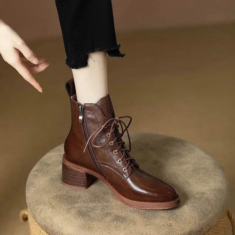 Women's black pointed-toe short tube boots with a 5.5cm heel on a plain background.