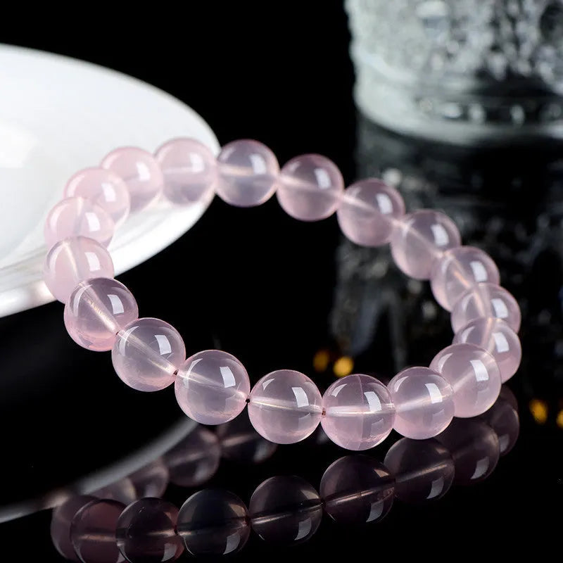 Pink crystal bracelet with round polished beads in natural starlight style showing size options from 6mm to 22mm diameter
