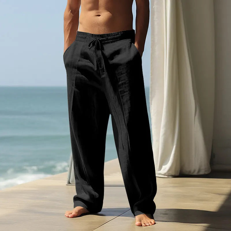 Men's loose casual cotton trousers in solid colours showing black, grey, and khaki options on a hanger.