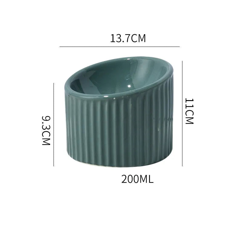 Elevated ceramic cat bowl in green, showing tilted design and raised height for feeding.