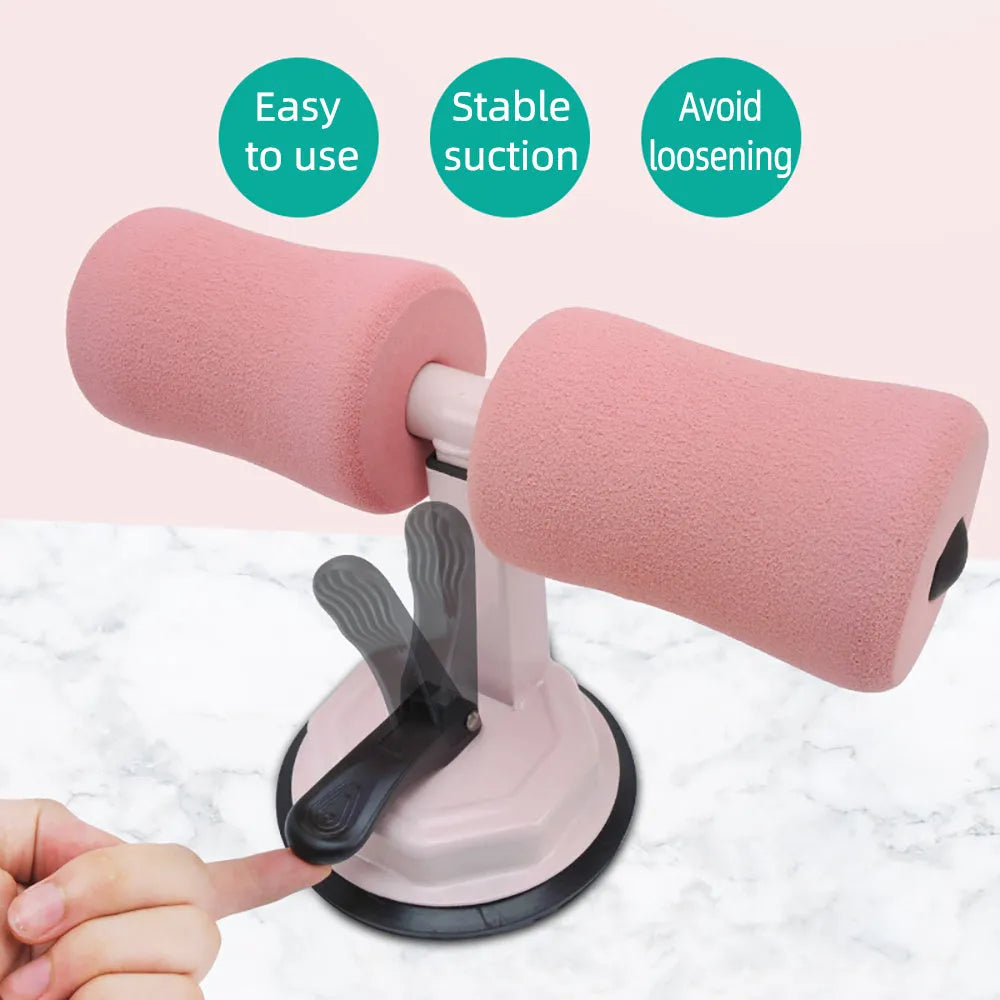 Pink adjustable sit-up bar floor assistant with foam pad and suction base on smooth floor